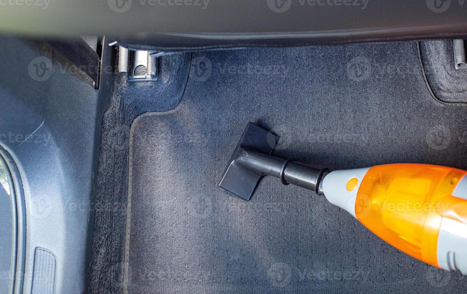 Cleaning a modern car interior with a vacuum cleaner from dirt and dust, background. Equipment photo