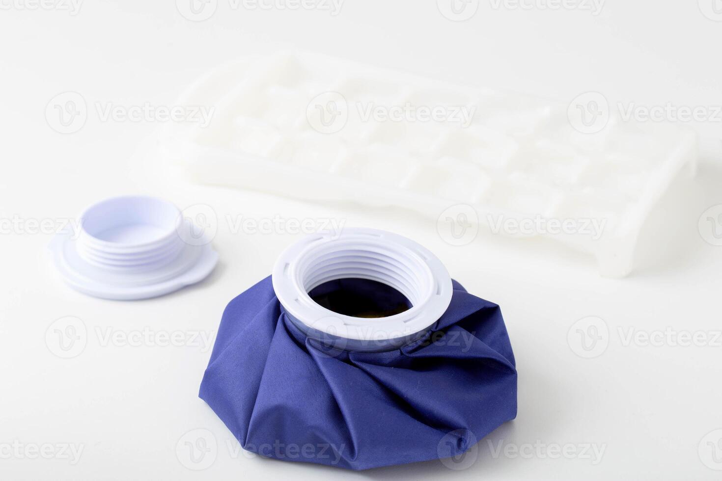 A medical blue cold bag with ice next to it. Pain relief and removal of edema with bruises, therapeutic photo