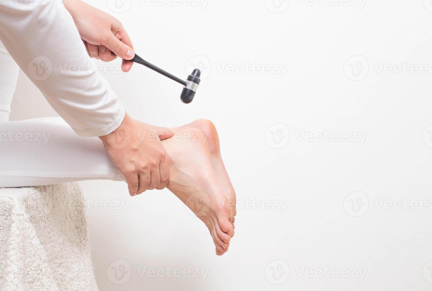 A neurologist doctor checks the Achilles reflex with a neurological hammer. Checking the tibial nerve and the presence of an intervertebral hernia of the spine, copy space photo