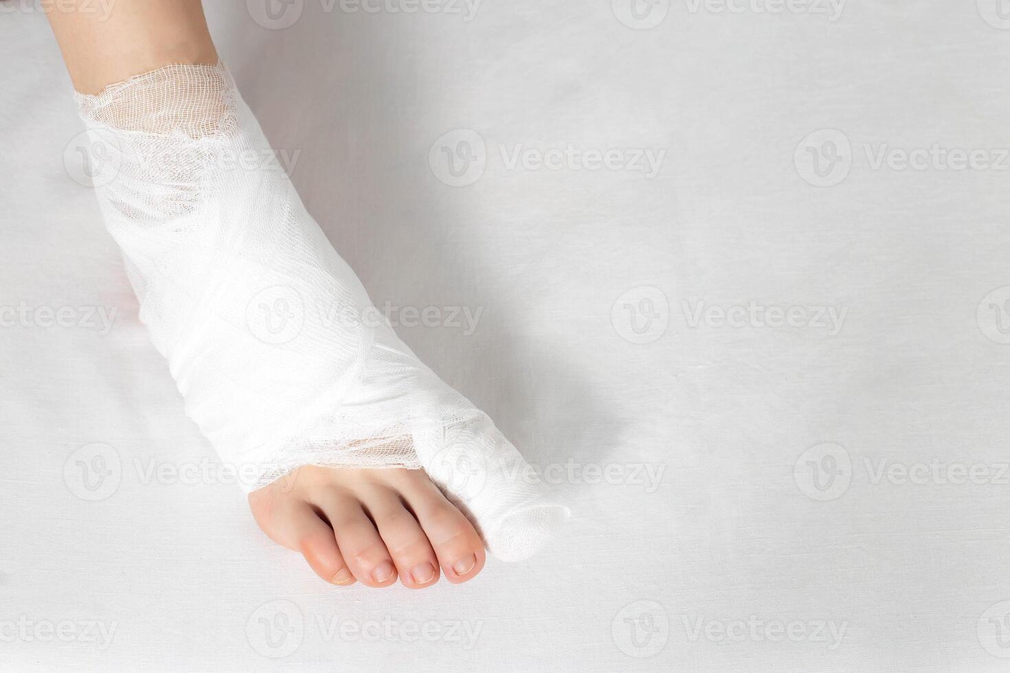 Bandaged big toe with foot on white background. Concept of fracture of the foot and thumb, close-up, copy space photo