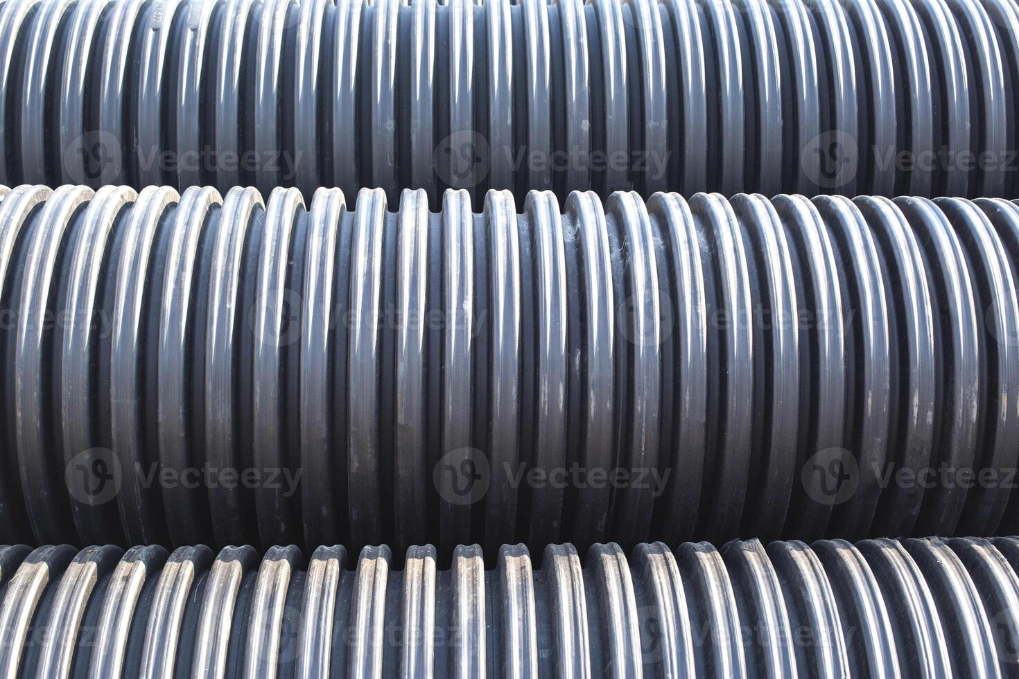Large diameter black polypropylene pipes for laying communications, drainage systems and heating mains under the road. Modern method and technology for supplying water and sewage, copy space, industry photo
