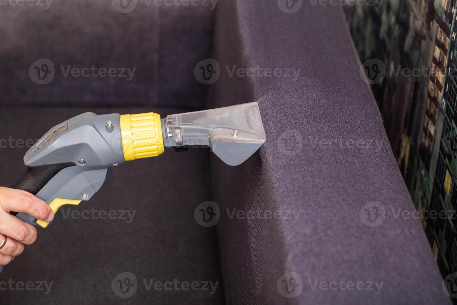 Dry cleaning of the black upholstery on the sofa with a special washing vacuum cleaner. Copy space for text photo