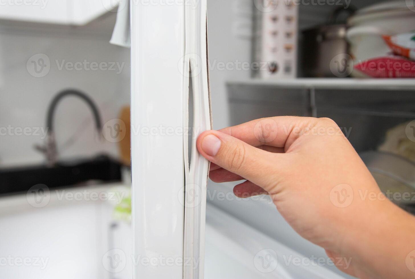Replacing the torn sealing rubber on the refrigerator door with a new rubber. photo