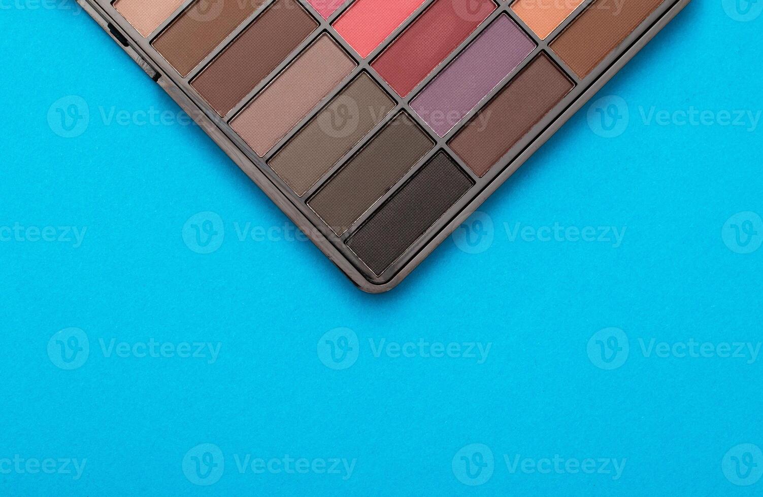 A set of modern eye shadows with powdery shades on a blue background. Soft texture and shading, brand, close-up. Copy space for text photo