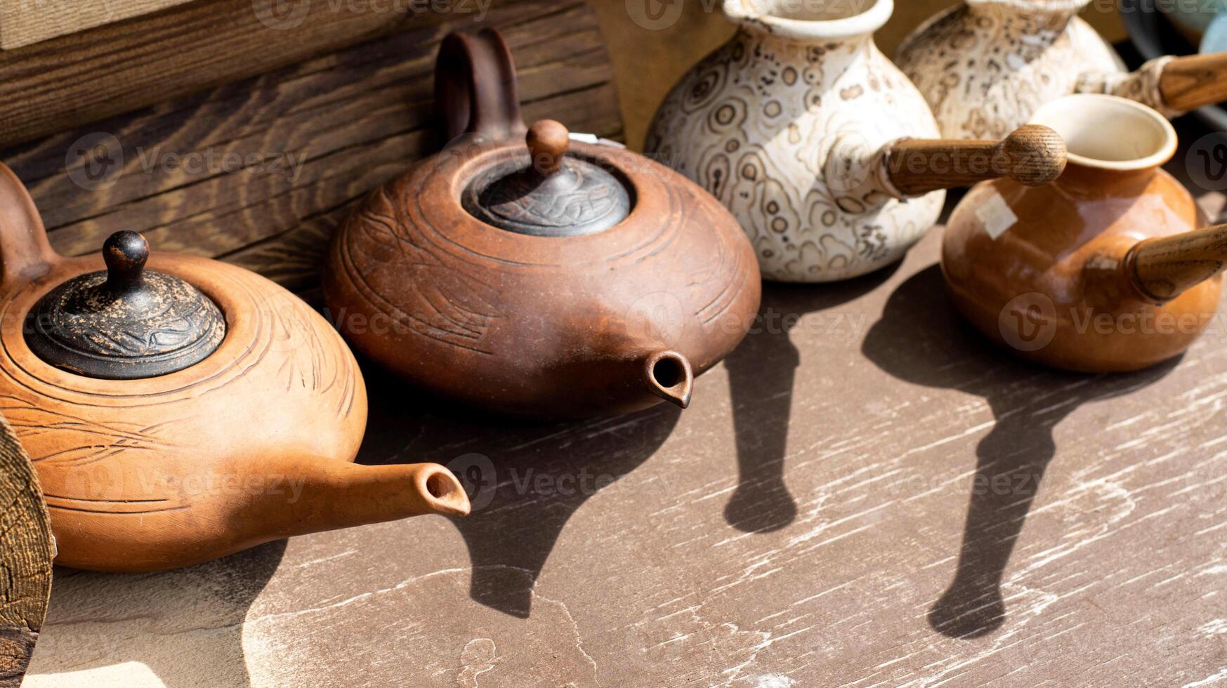 Clay teapots with long spouts and lids. Clay dishes. Copy space for text photo