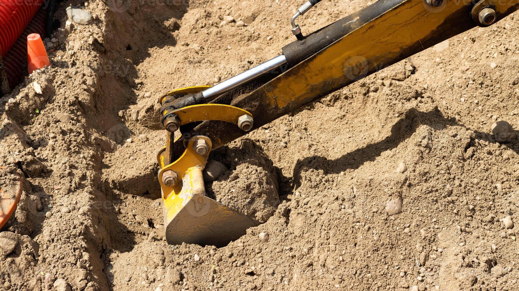 A yellow boom with a bucket near a children's mini excavator in an amusement park. Entertainment for children. photo