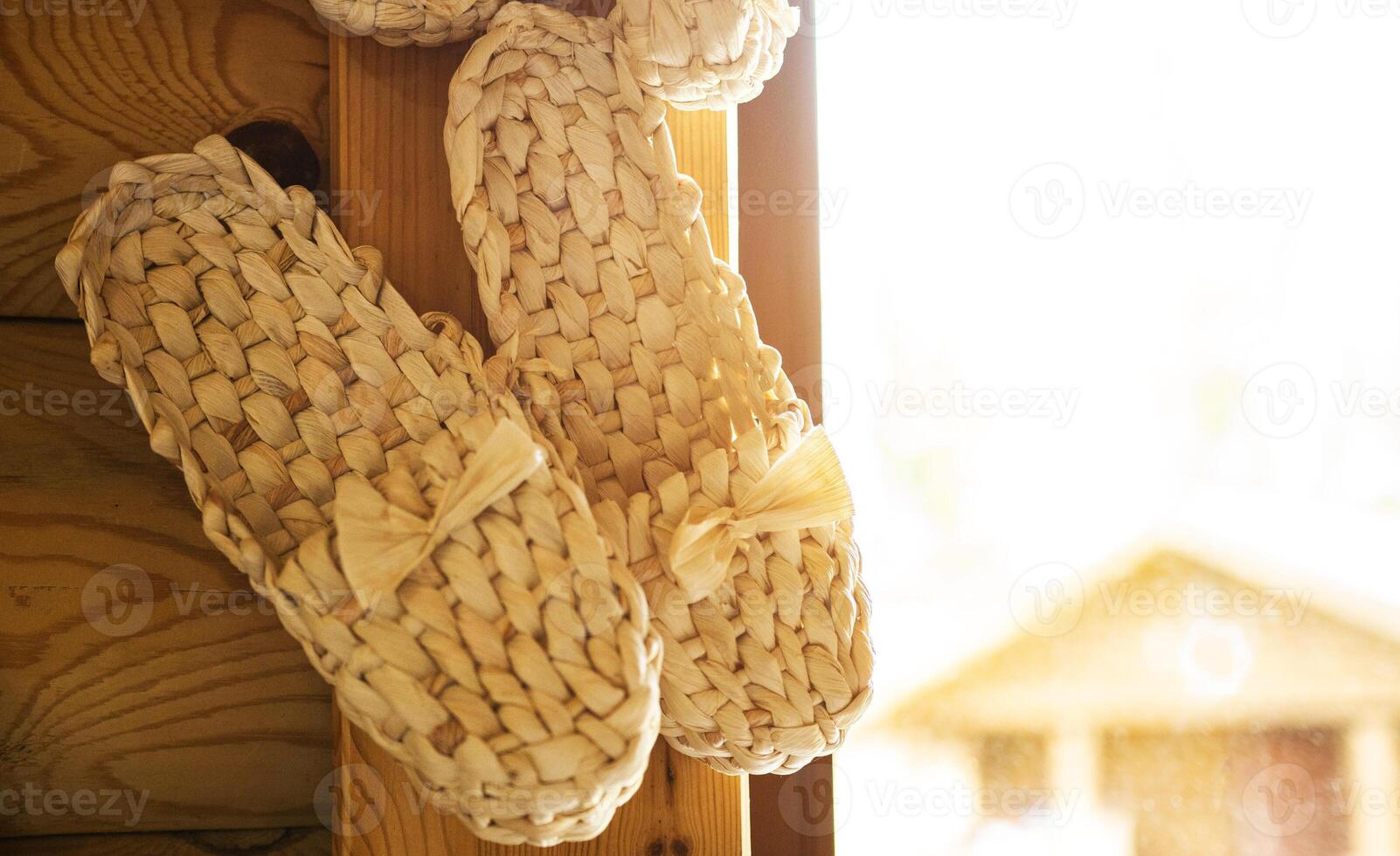 Bast shoes woven from the bark hang. Handmade, old shoes, traditional. Copy space for text photo