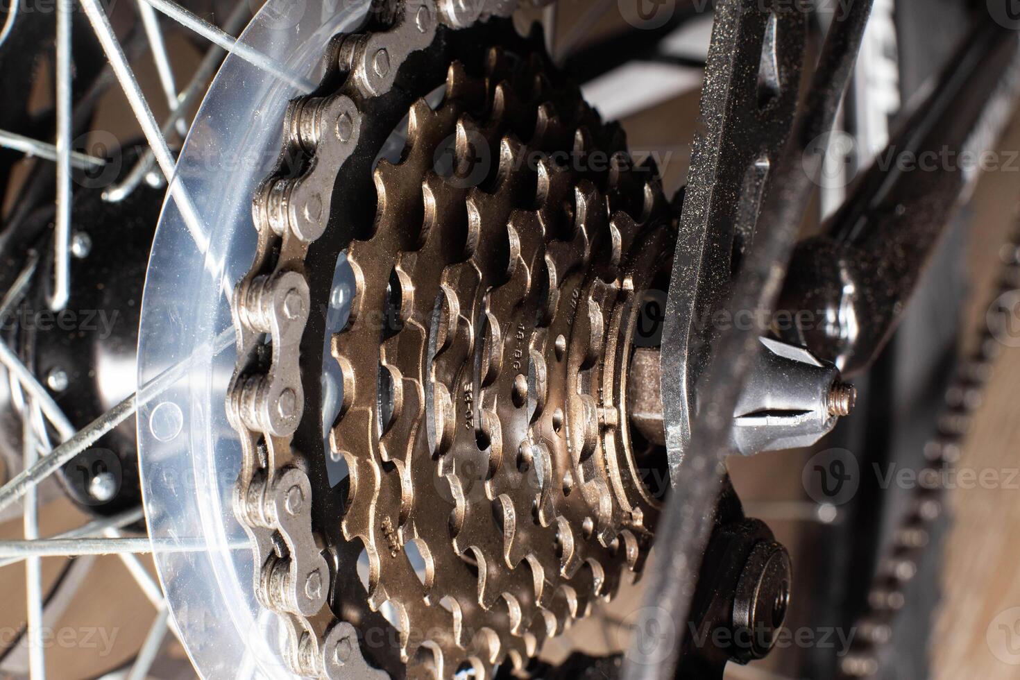 Gearshift on mountain bike MTB, chain moves on rings. Changes speeds. Shift gears on bicycle crank. Work of chain drive chainset. Front derailleur. Macro closeup low angle shot. Wheel spins and turns photo