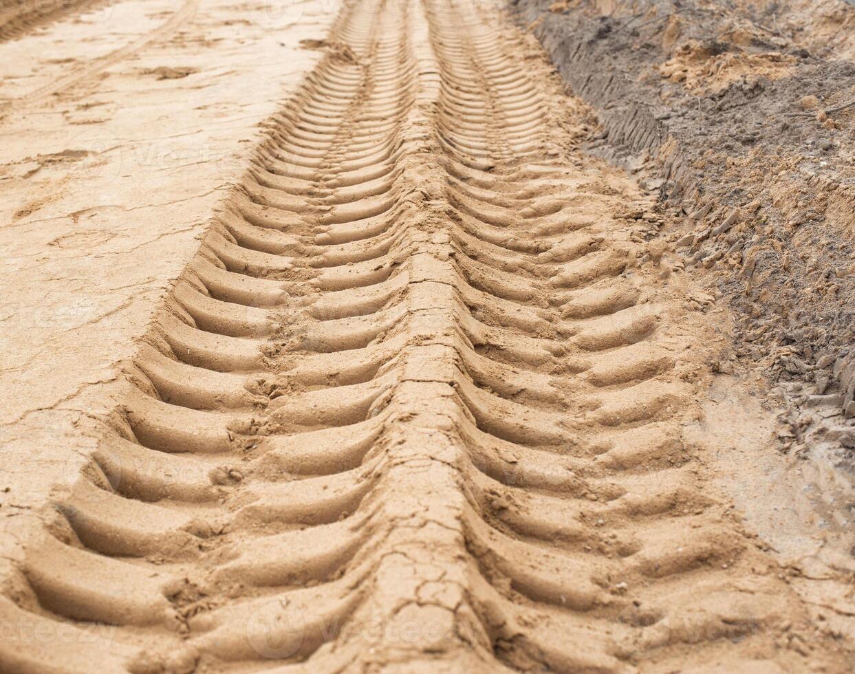 Track from the wheels of construction equipment and a truck on the sand, background, copy space photo