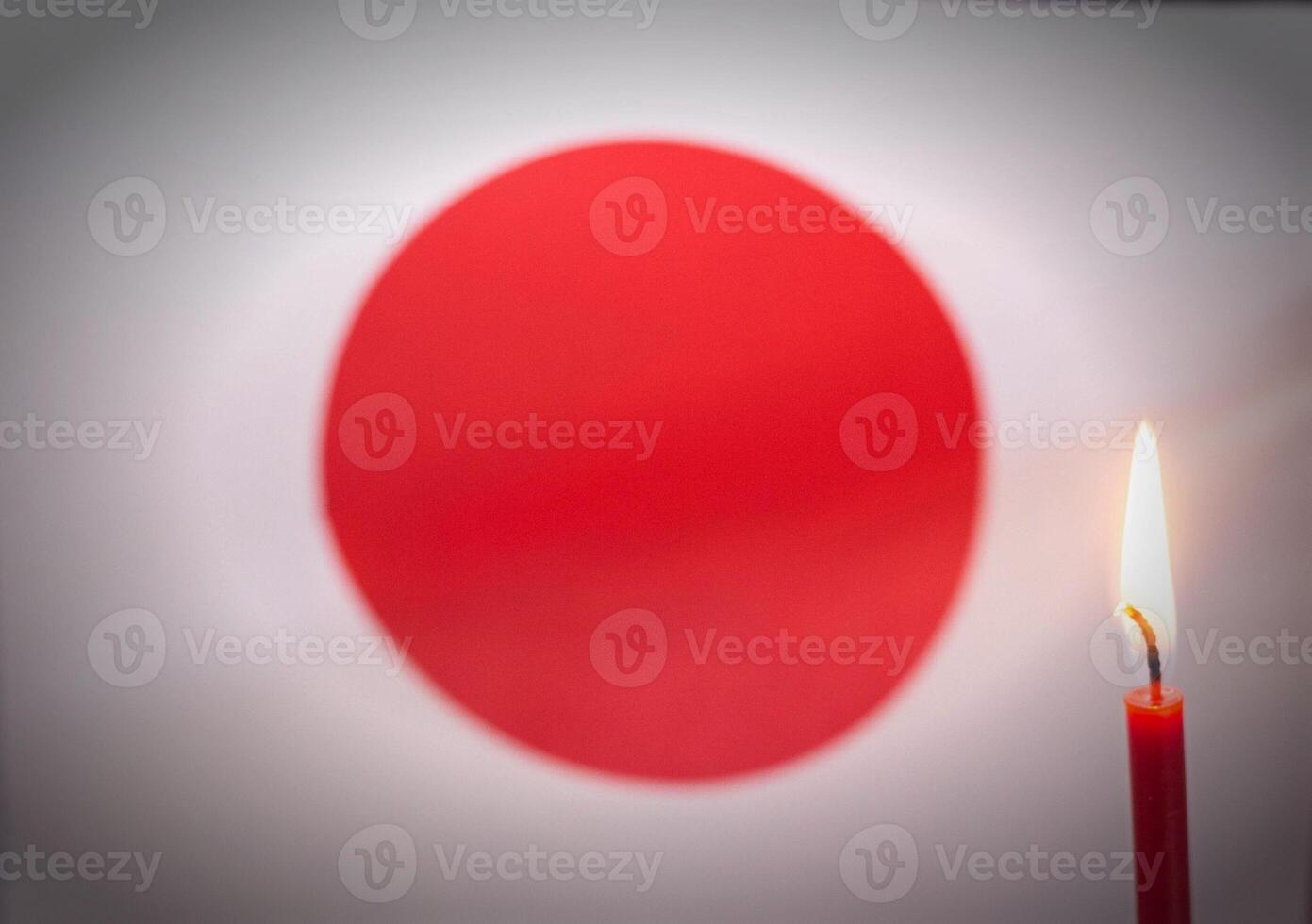 Burning candle on the background of the flag of Japan. The concept of mourning and sorrow in the country, terrorism photo