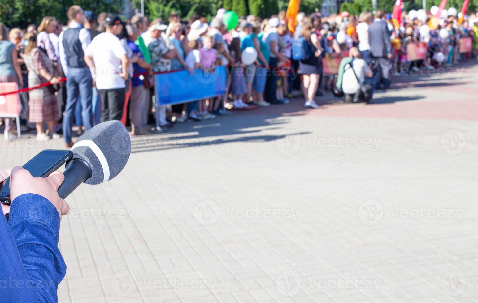 hands of a reporter with a microphone on the background of a crowd of people. Interview and news concept, Copy space for text photo