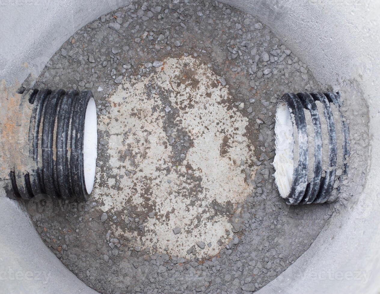 Construction of sewage engineering structures for the drain of sanitary water and rainwater, industry. Plastic pipes in the sewage system in reinforced concrete rings, sewer network photo