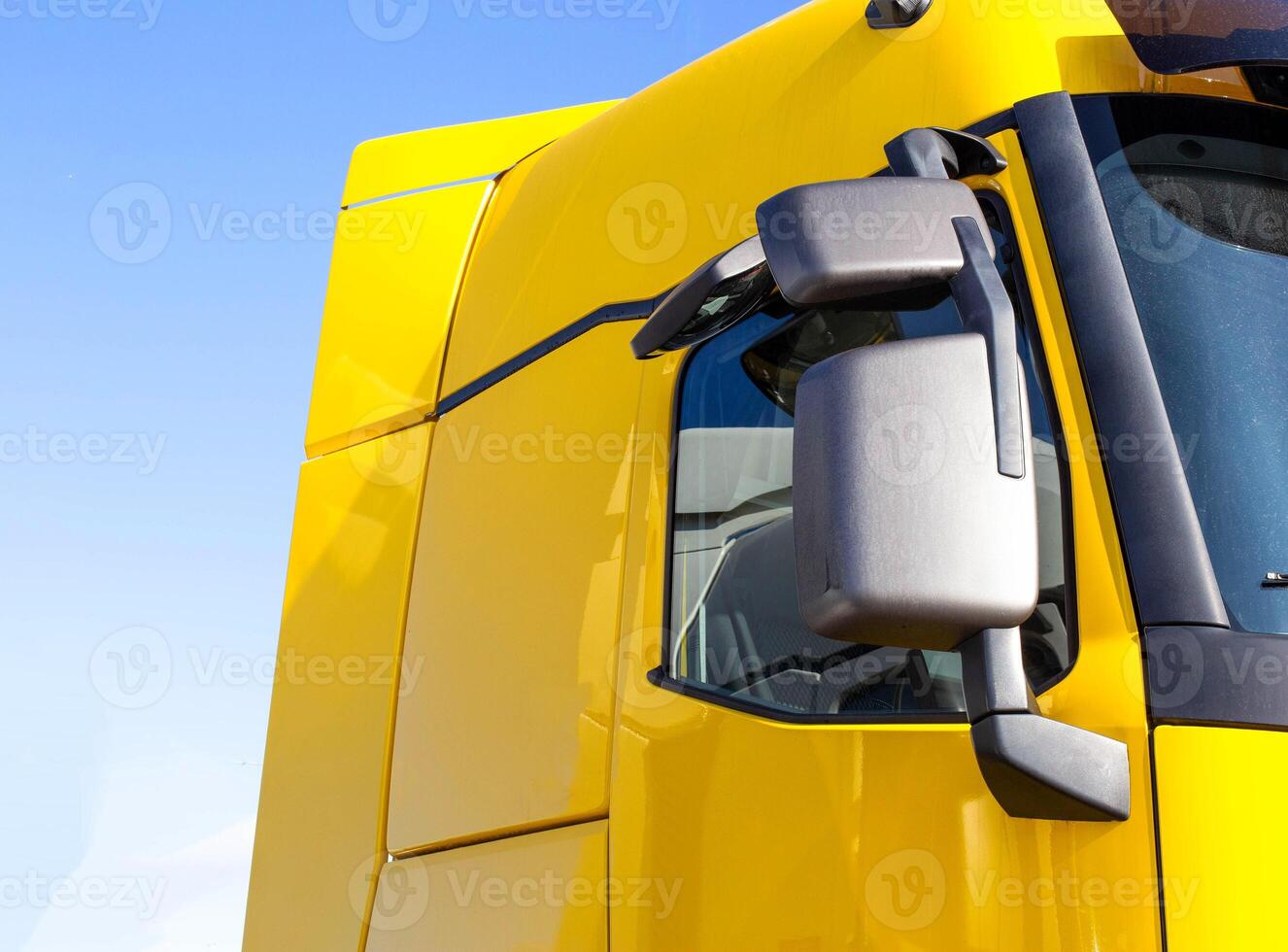 modern, streamlined truck cab with good aerodynamics with a rearview mirror. Yellow truck cab, background photo