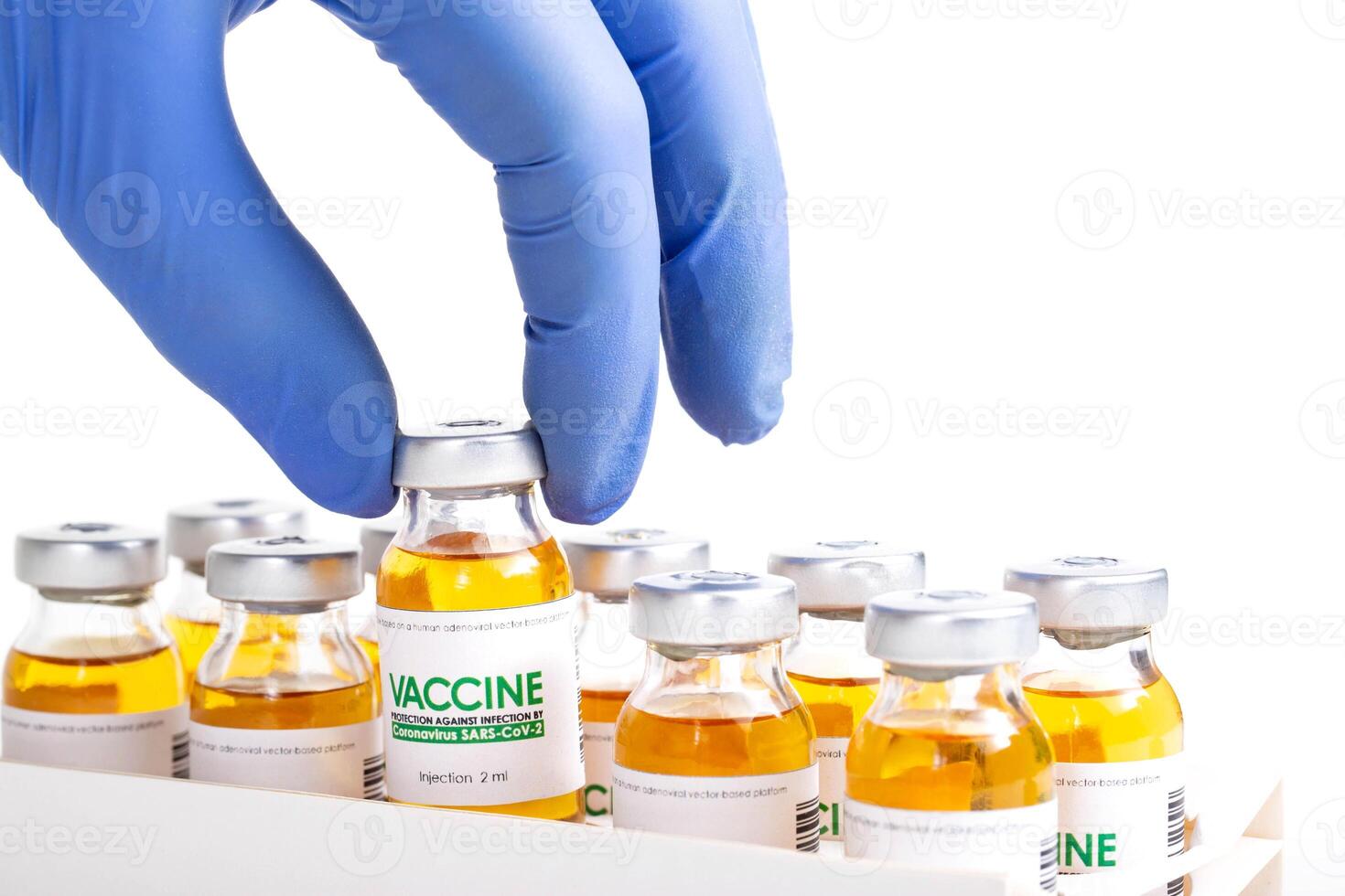 Doctor in medical glove holds in his hand a vial of vaccine for injection for coronavirus COVID-19 cure in research laboratory. Vaccination concept, pandemic. Macro. photo