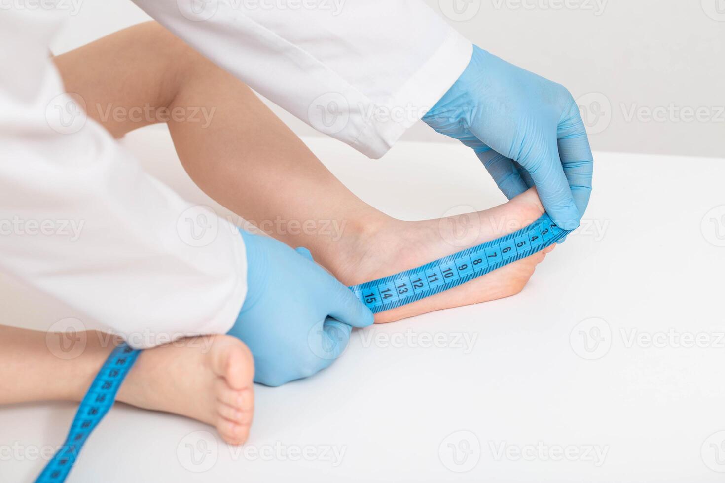 Measuring the foot of a child with a measuring tape on a white background. Flatfoot disease concept, child growth measurement, close-up. Copy space for text photo
