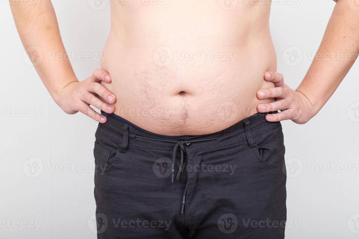 A man with a fat and flabby belly on a white background. Obesity and obesity concept, wrong lifestyle photo