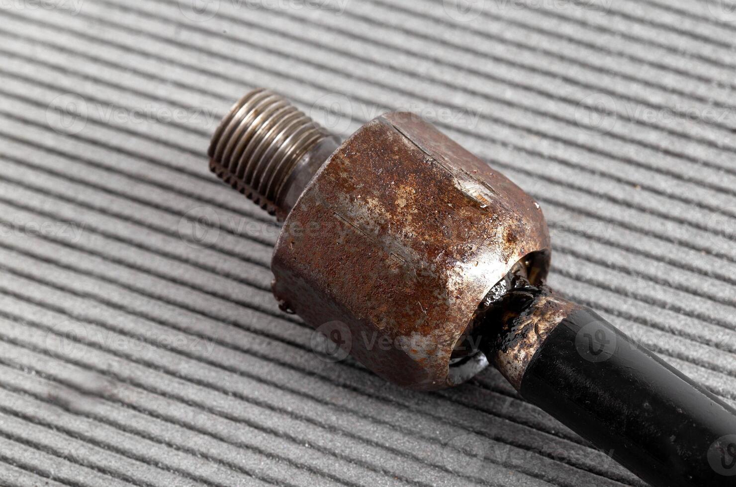 Old rusty steering rod on a gray background, close-up. photo