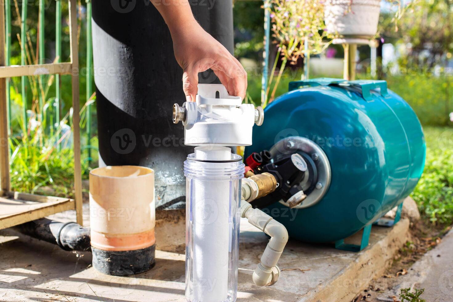 Water supply system from a well in a country house. New water filter. Hydraulic accumulator for storing water volume. Replacing a new water filter. photo