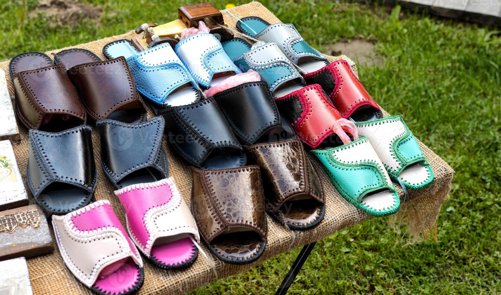 Trading in the market of shoes with flip flops made of genuine leather. Multicolour woven leather sandals, comfortable photo