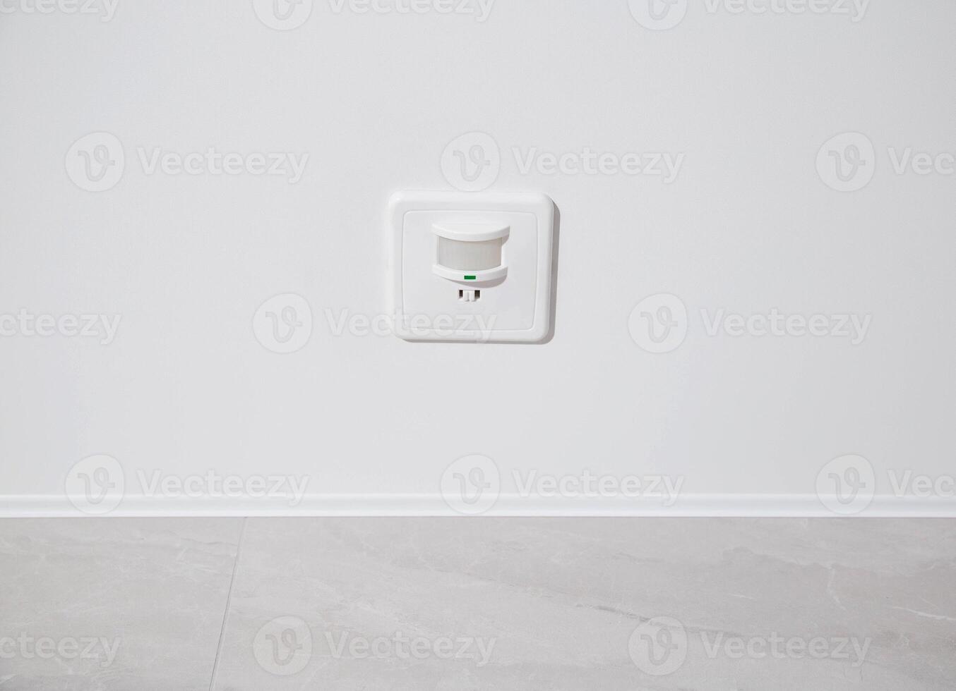 Modern motion sensor for turning on and off the light on the ceiling. photo