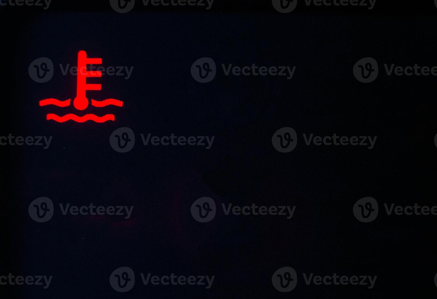 Red indicator of car engine coolant on a black background. Car overheating concept, copy space for text photo
