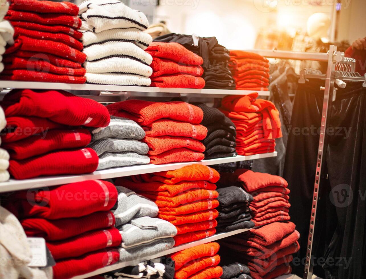 Selling in the store of warm things sweaters and jacket. Fashionable and stylish clothes, a stack of multi-colored natural jackets photo