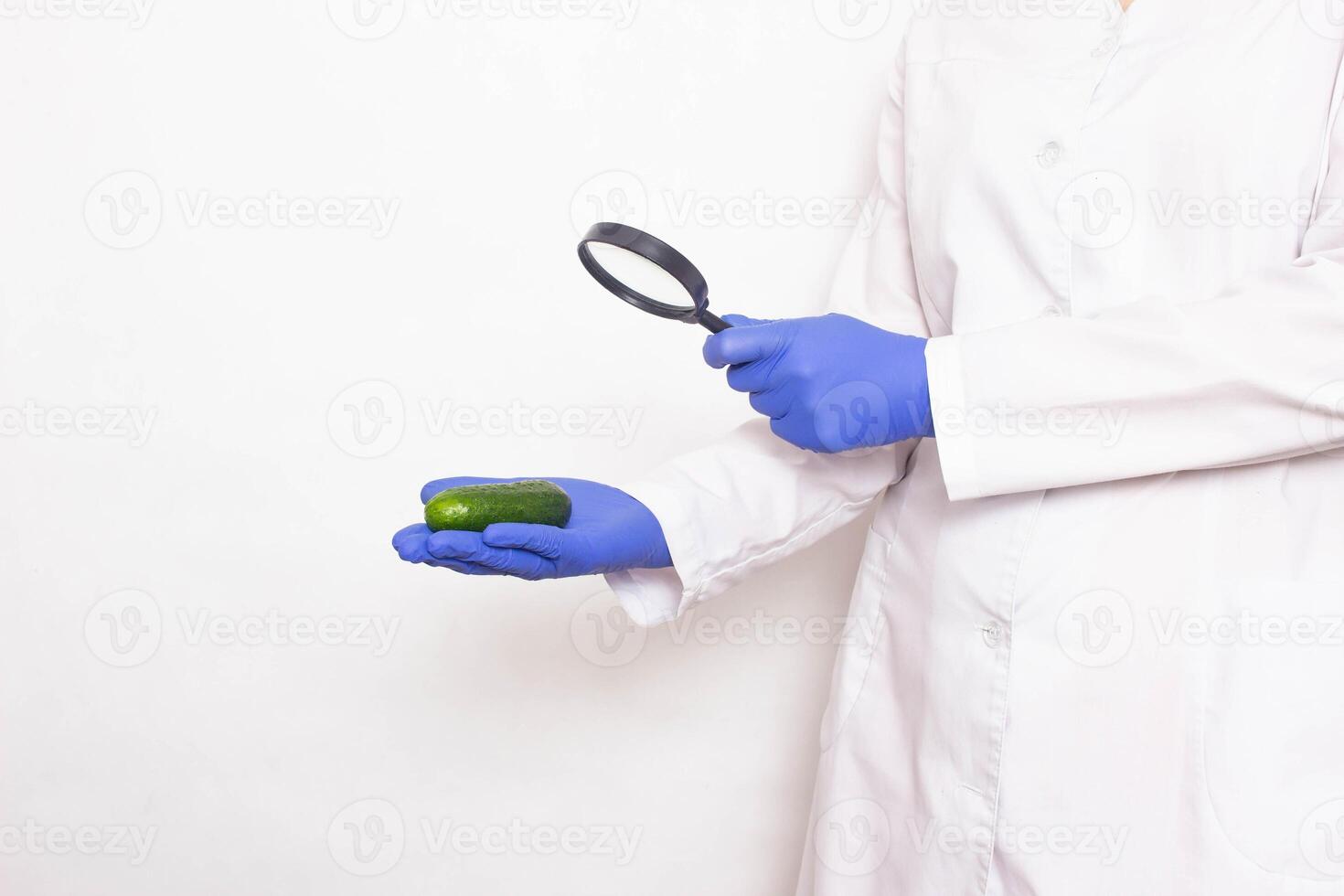 The doctor looks at the cucumber through a magnifying glass. Penis size concept for men, penis enlargement, copy space photo
