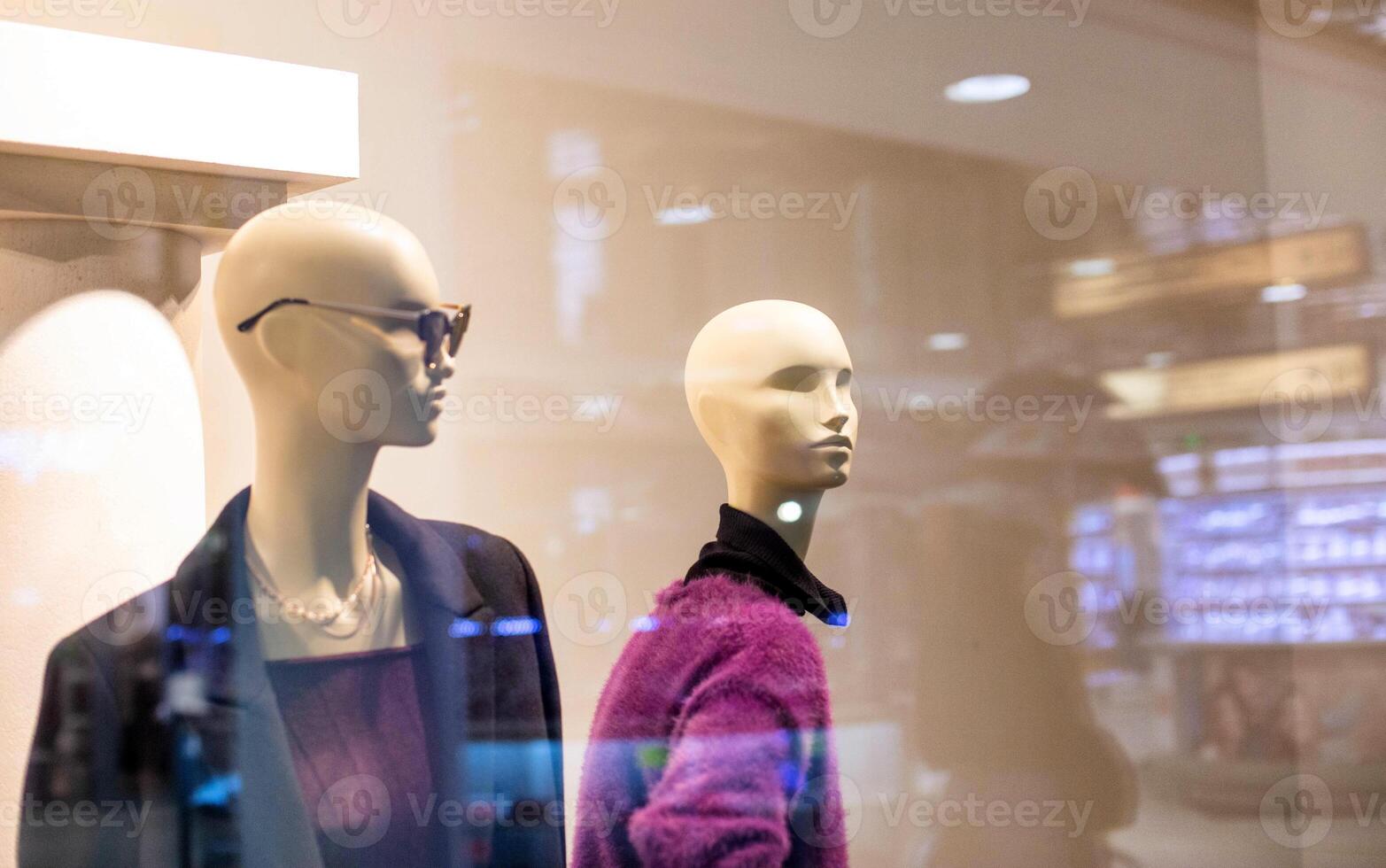 Two fashionable and stylish mannequins in modern glasses and warm business clothes. The concept of selling quality and stylish clothes, background photo