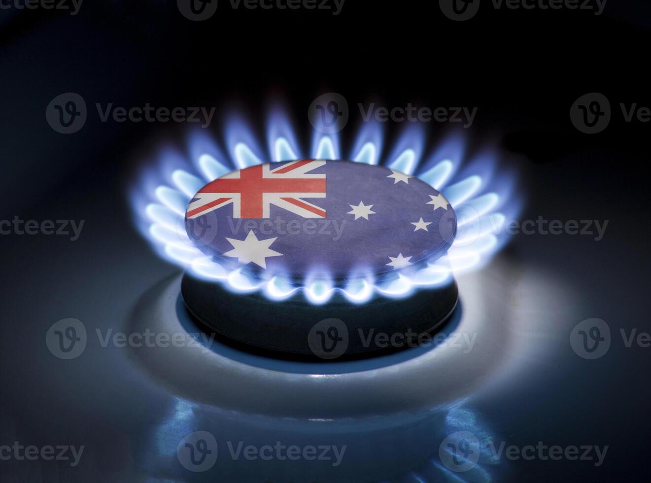 Burning gas burner of a home stove in the middle of which is the flag of the country of Australia. Gas import and export delivery concept, price per cubic meter, transit, background photo