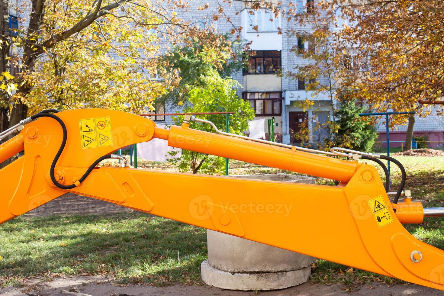 Yellow excavator bucket on the background of a residential building in the yard. The concept of the installation of water supply, industry photo
