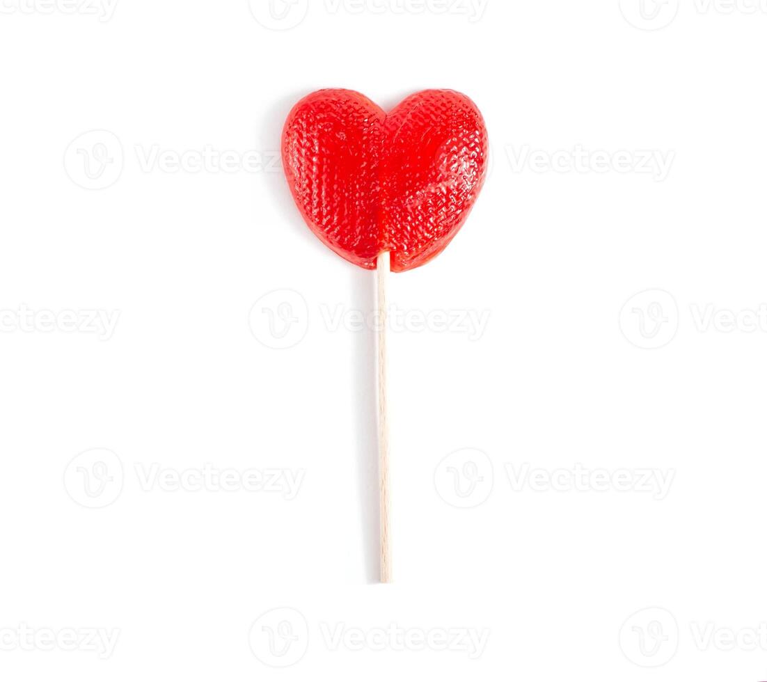 Red candy in the form of a heart on a stick for lovers. White background, isolate, close-up photo