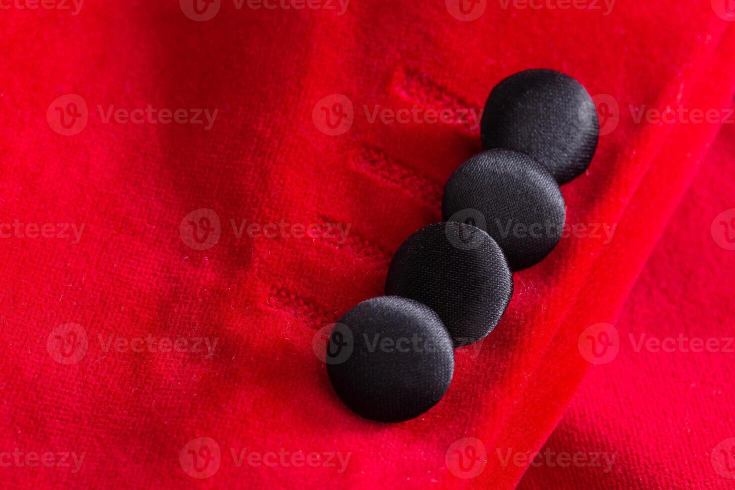 Black buttons on the red sleeve of the showman's jacket, macro. Material photo