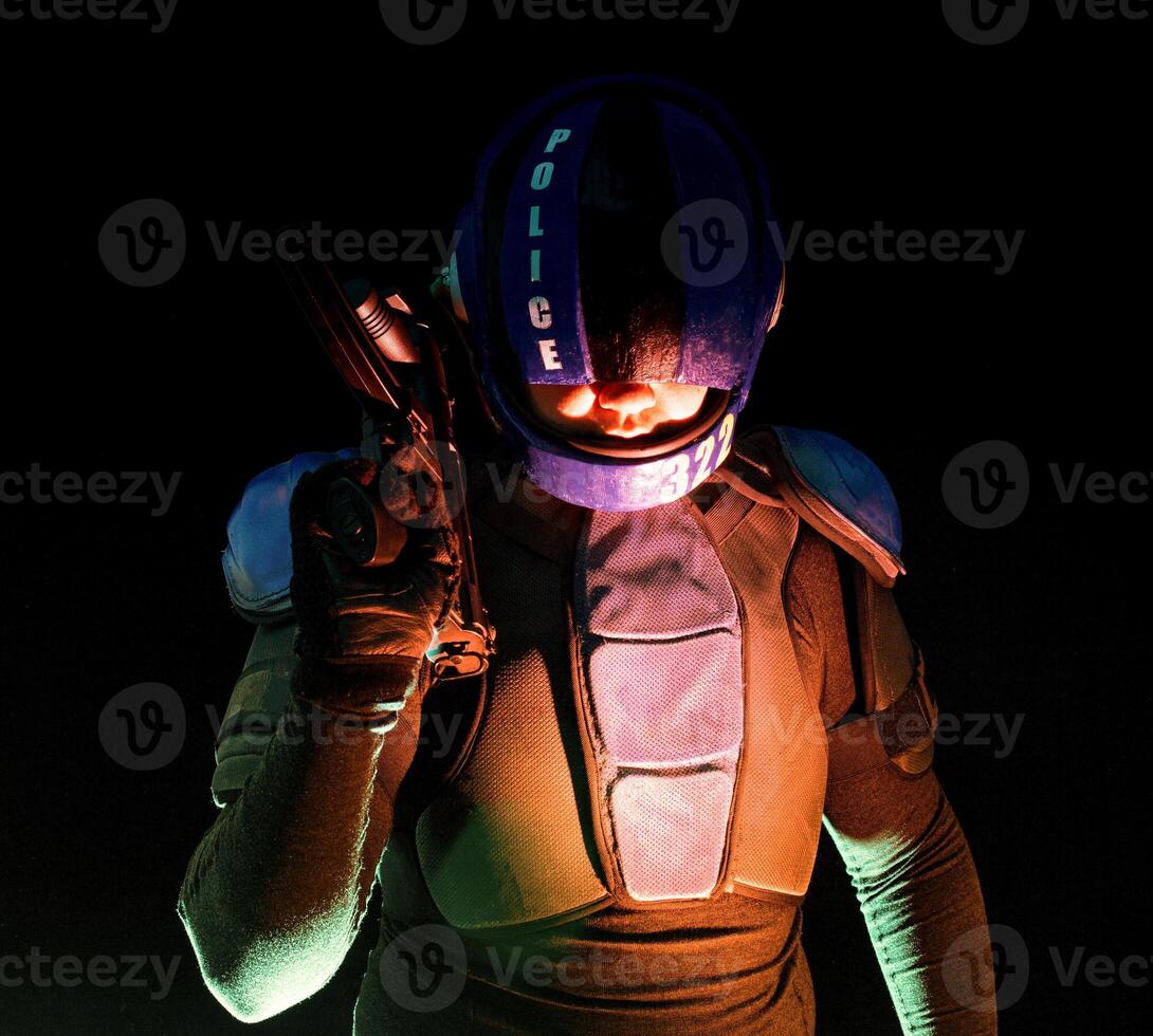 Cyberpunk concept, future world. Police officer cop in dark, halfman bionic cyborg or reloads gun, twitches cocking lever, Stands looks at camera in dark. Science fiction scene, fantasy, sci. photo