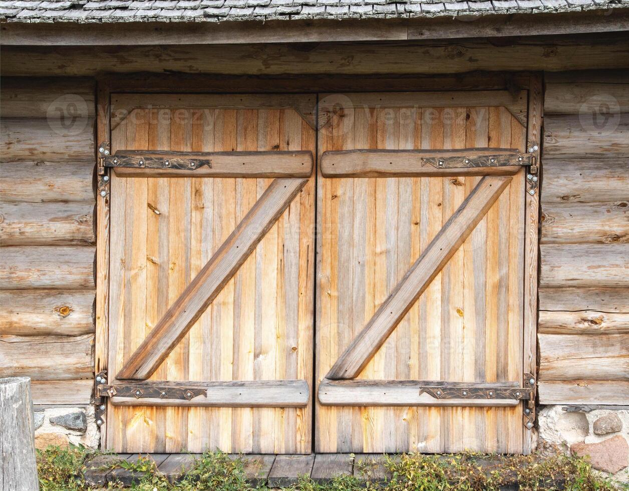 Wooden gate in a log shed in the village and wrought iron hinges, old architecture, background photo
