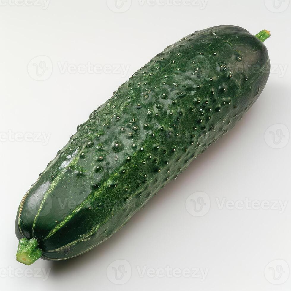 Small green cucumber with small bumps and a stem. photo