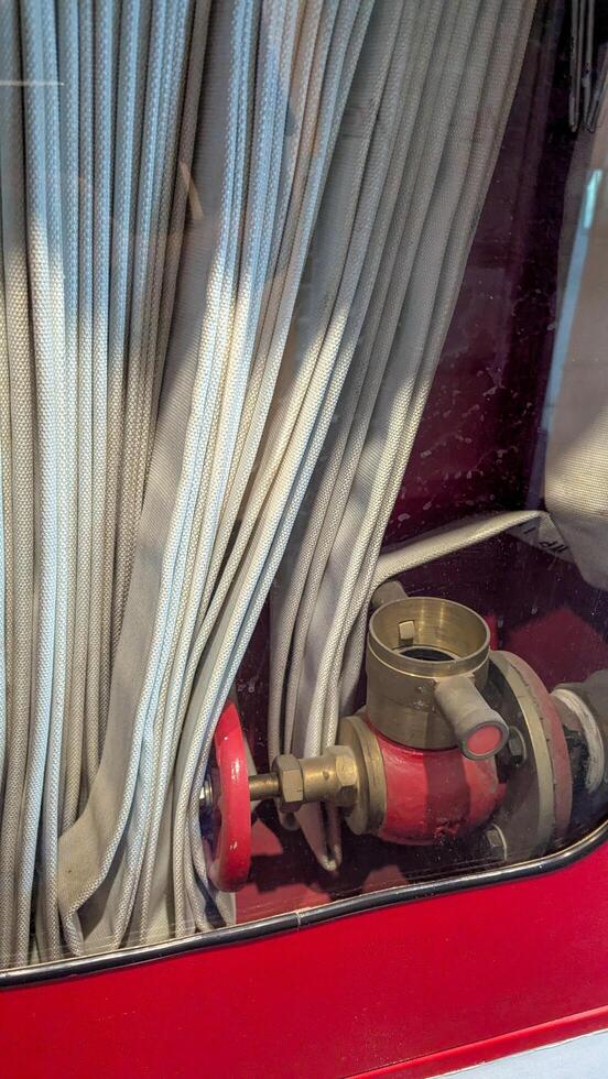 Hose connection and valve inside a fire truck, showcasing essential firefighting equipment stored neatly for quick access during emergencies photo
