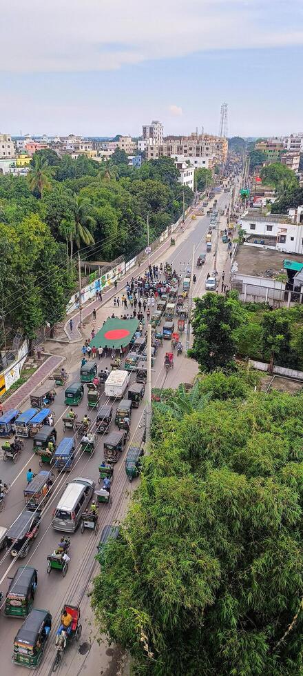 Traffic congestion in a bustling urban area with pedestrians and vehicles along a busy road in a city during daylight hours photo
