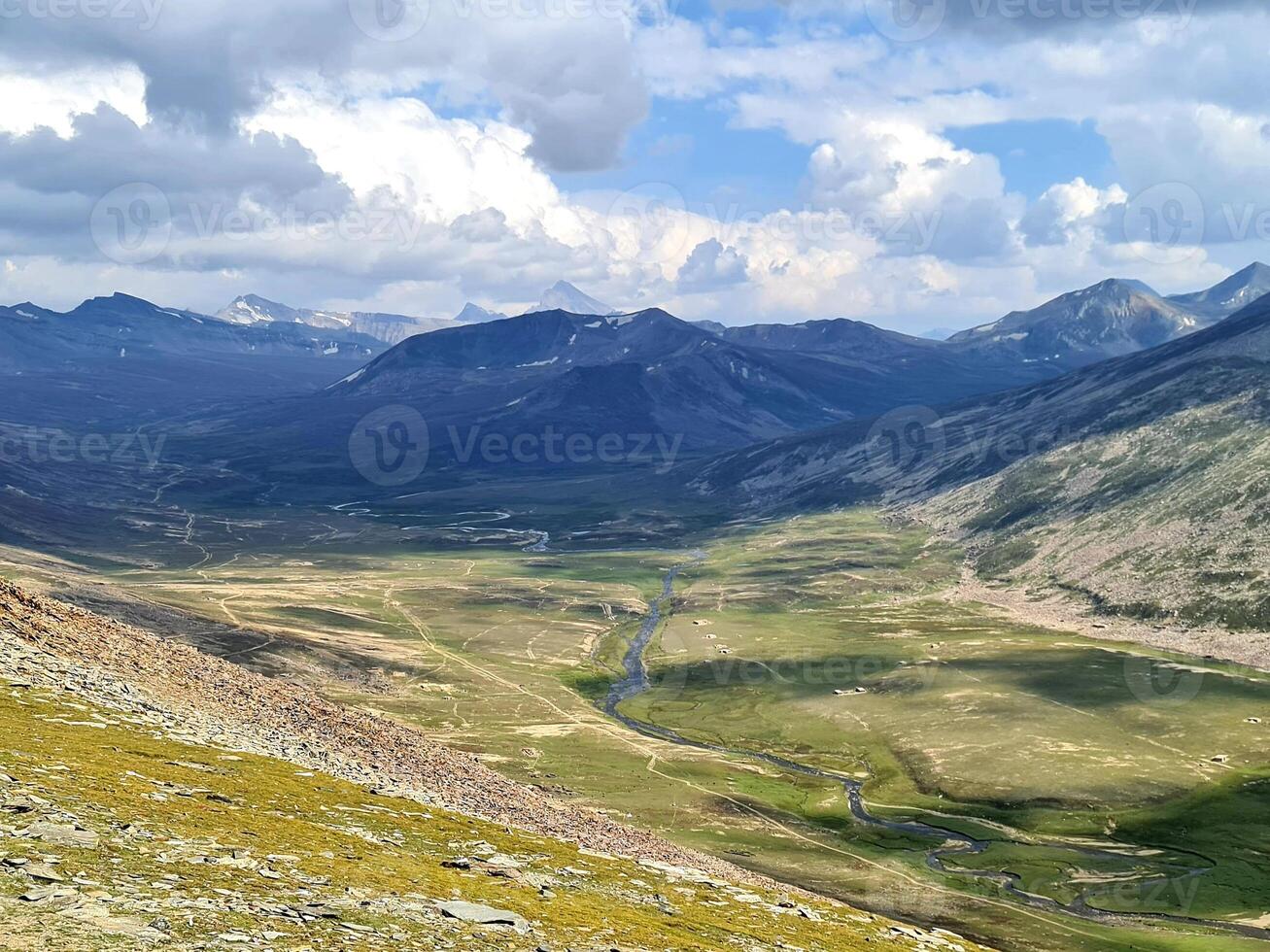 A view of a valley and mountains from a mountain top photo