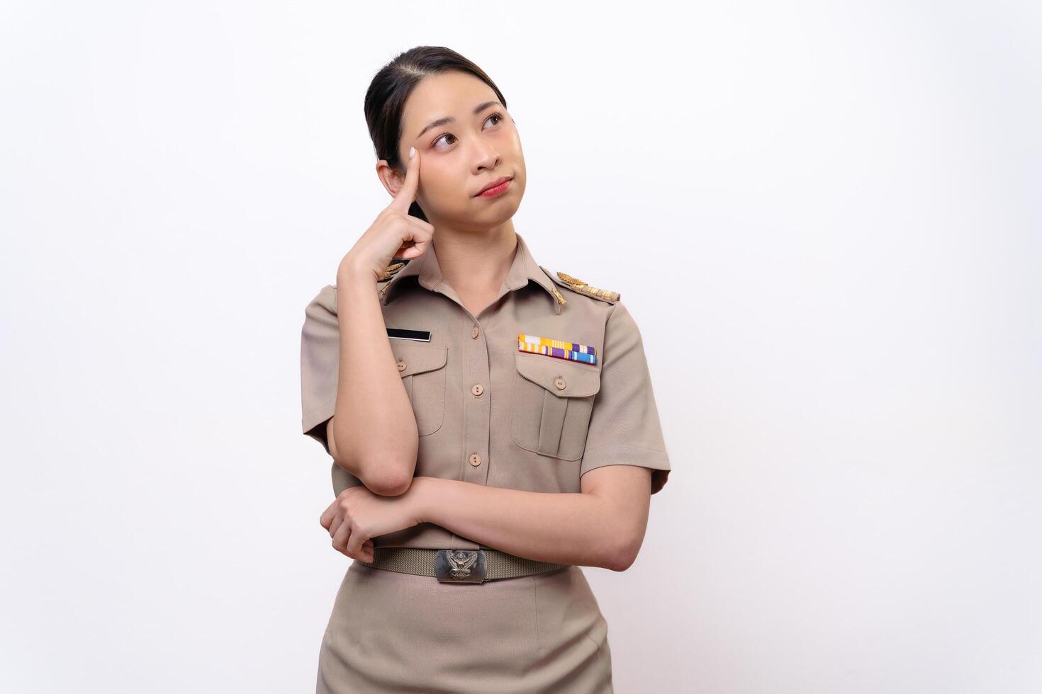 A curious woman in a Thai asian teacher uniform is looking to the side. she is thinking something. photo