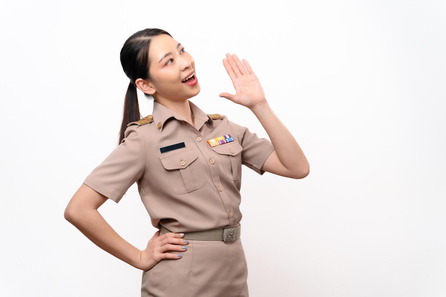 A woman in a Thai asian teacher uniform is open mouths raising hands to announcement photo