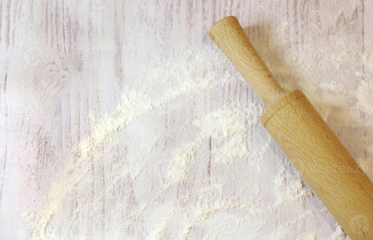 Background for baking with space for text. Rolling pin and flour on a white wooden surface. Top view with empty area for text. photo