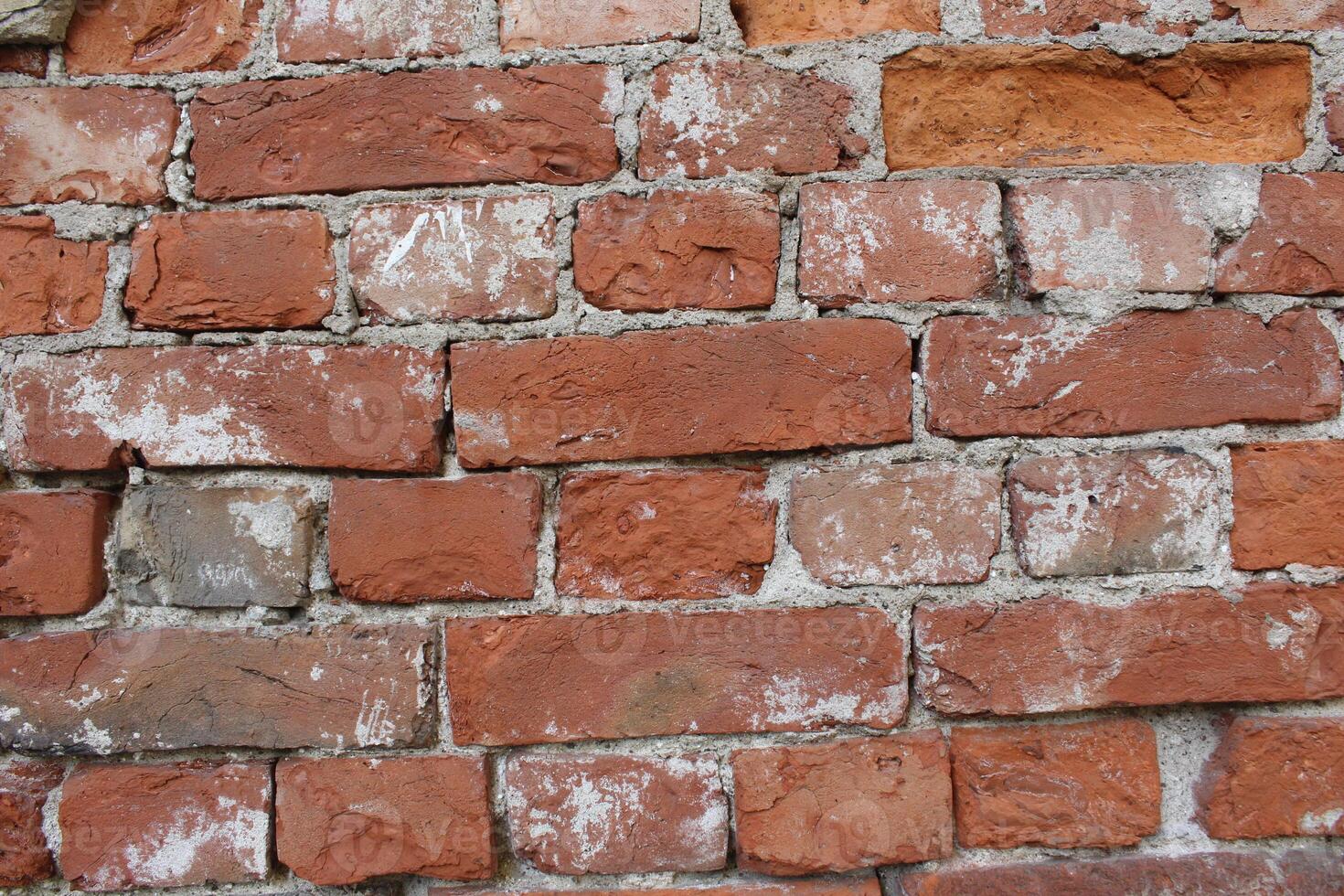 Red brick wall with remnants of cement, cement, mortar. Brutal construction background photo