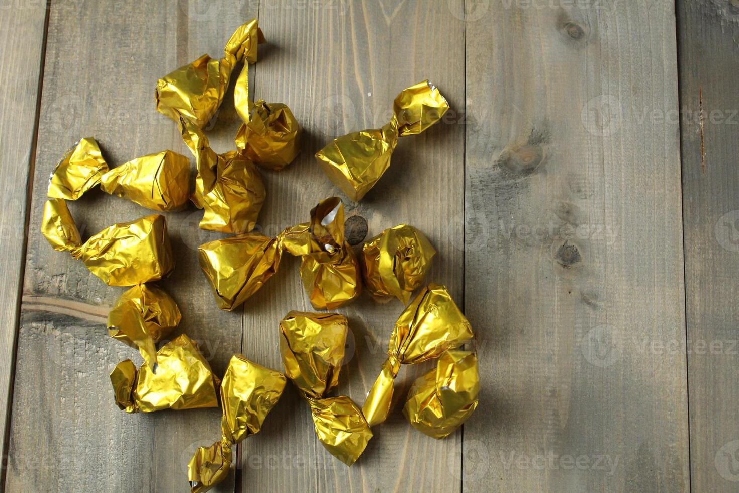 Scattering of candies in a wrapper on a gray background, top view, upper angle. Healthy candies photo