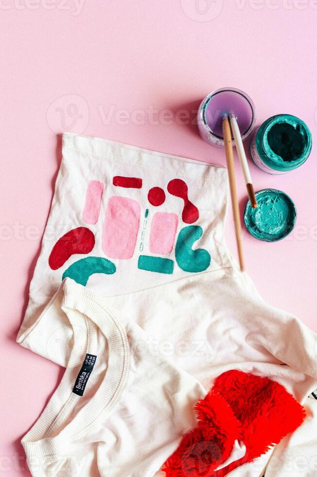 a shirt with a red heart on it and paint brushes photo