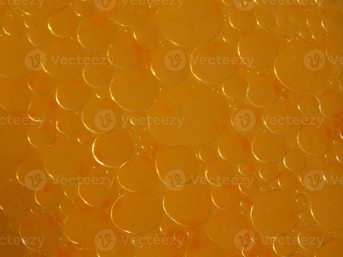 a close up of a orange liquid with bubbles photo