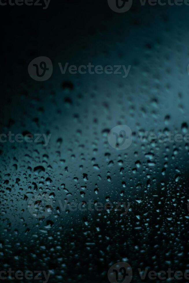 raindrops on a window, with a dark background photo