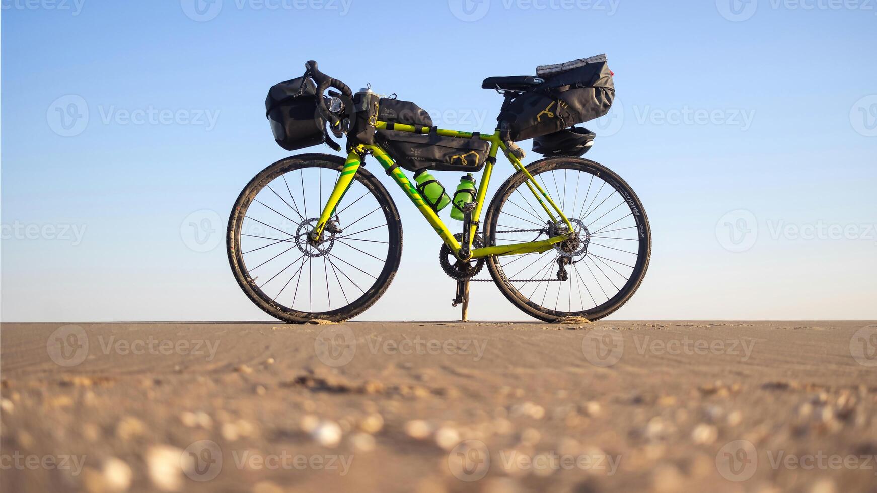 a bike with a bag on it is parked on the beach photo