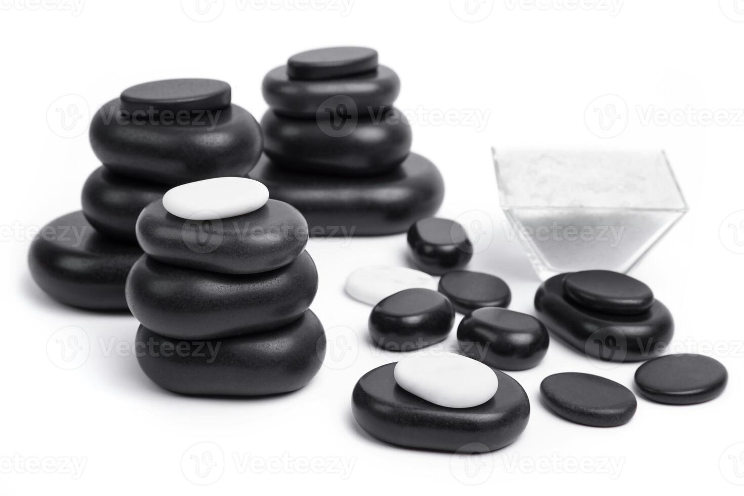 a pile of black and white stones with a glass container photo
