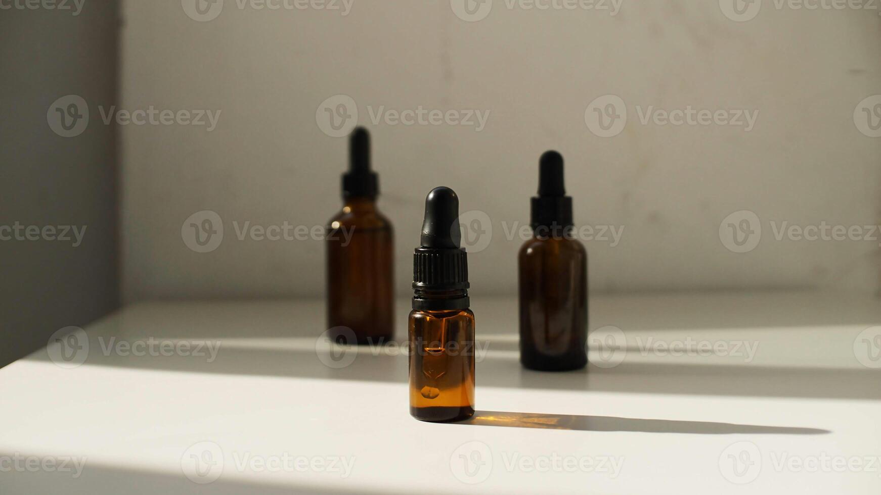 three bottles of essential oils sit on a table photo