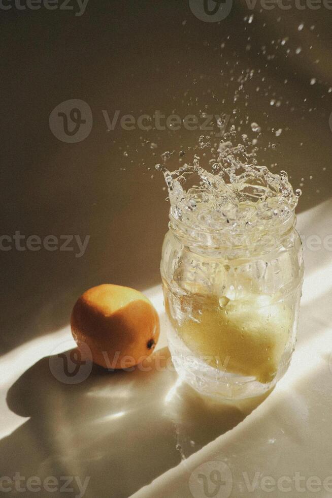 a lemon and a glass of water on a table photo